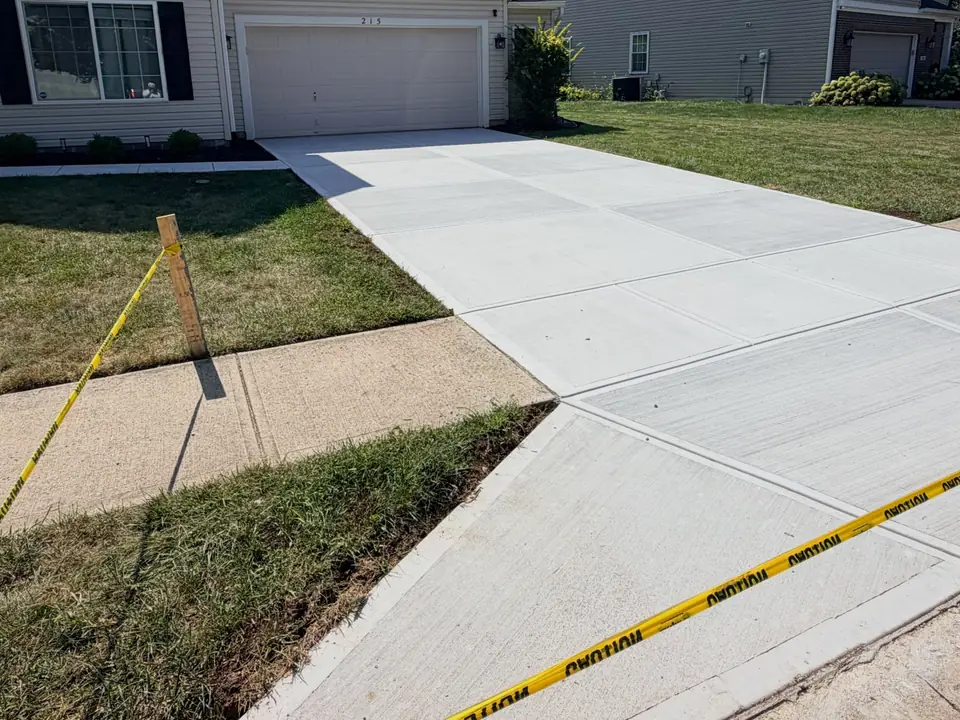 Concrete driveway and front walk beside a residential home