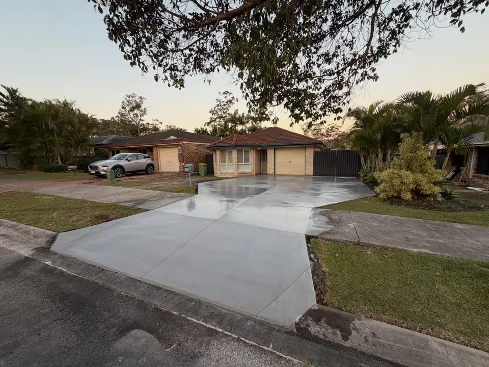 Wide concrete driveway running from the street to a home garage