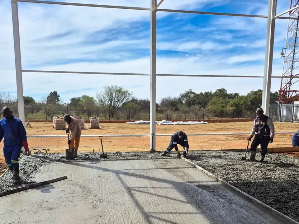 Crew leveling and finishing a fresh concrete slab