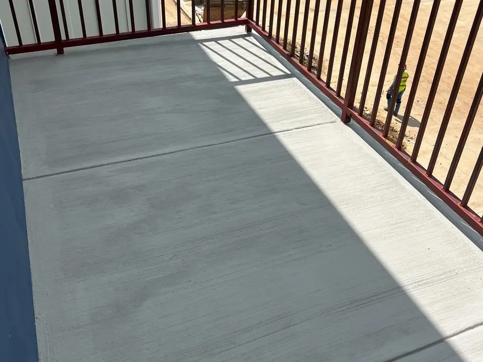 Broom-finished concrete patio along a deck railing