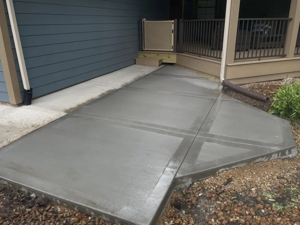 Concrete entry patio connecting a porch and side path