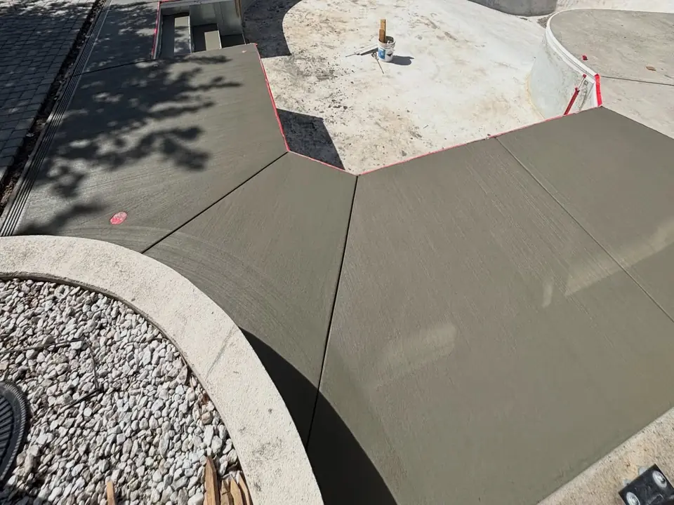 Broom-finished concrete deck and steps around a pool under construction, photo 2 of 10