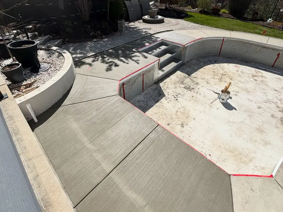 Broom-finished concrete deck and steps around a pool under construction