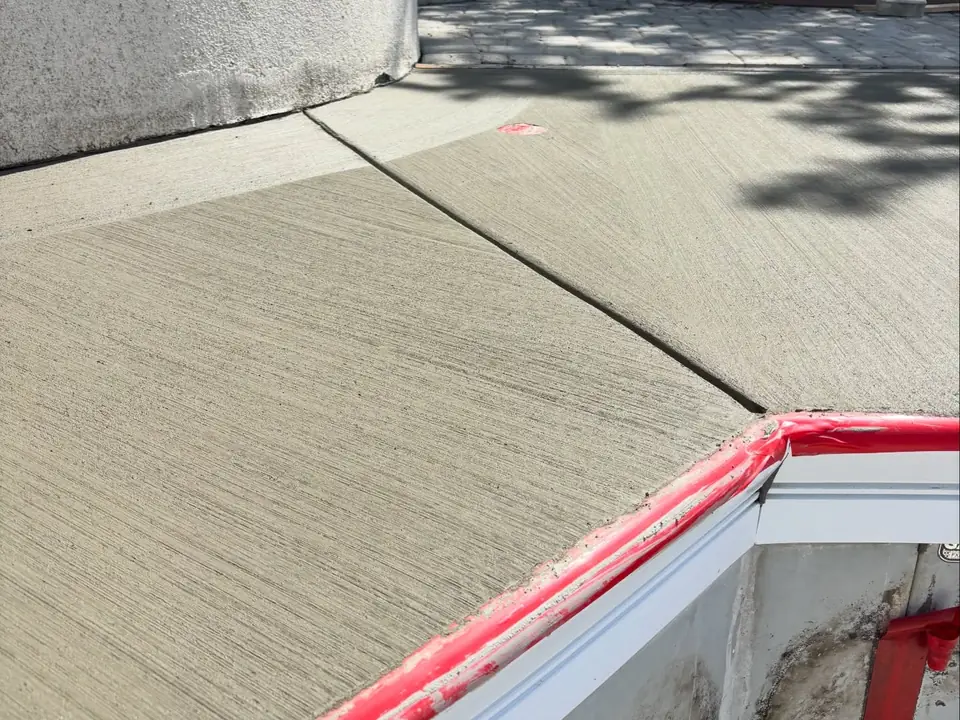 Broom-finished concrete deck and steps around a pool under construction, photo 7 of 10
